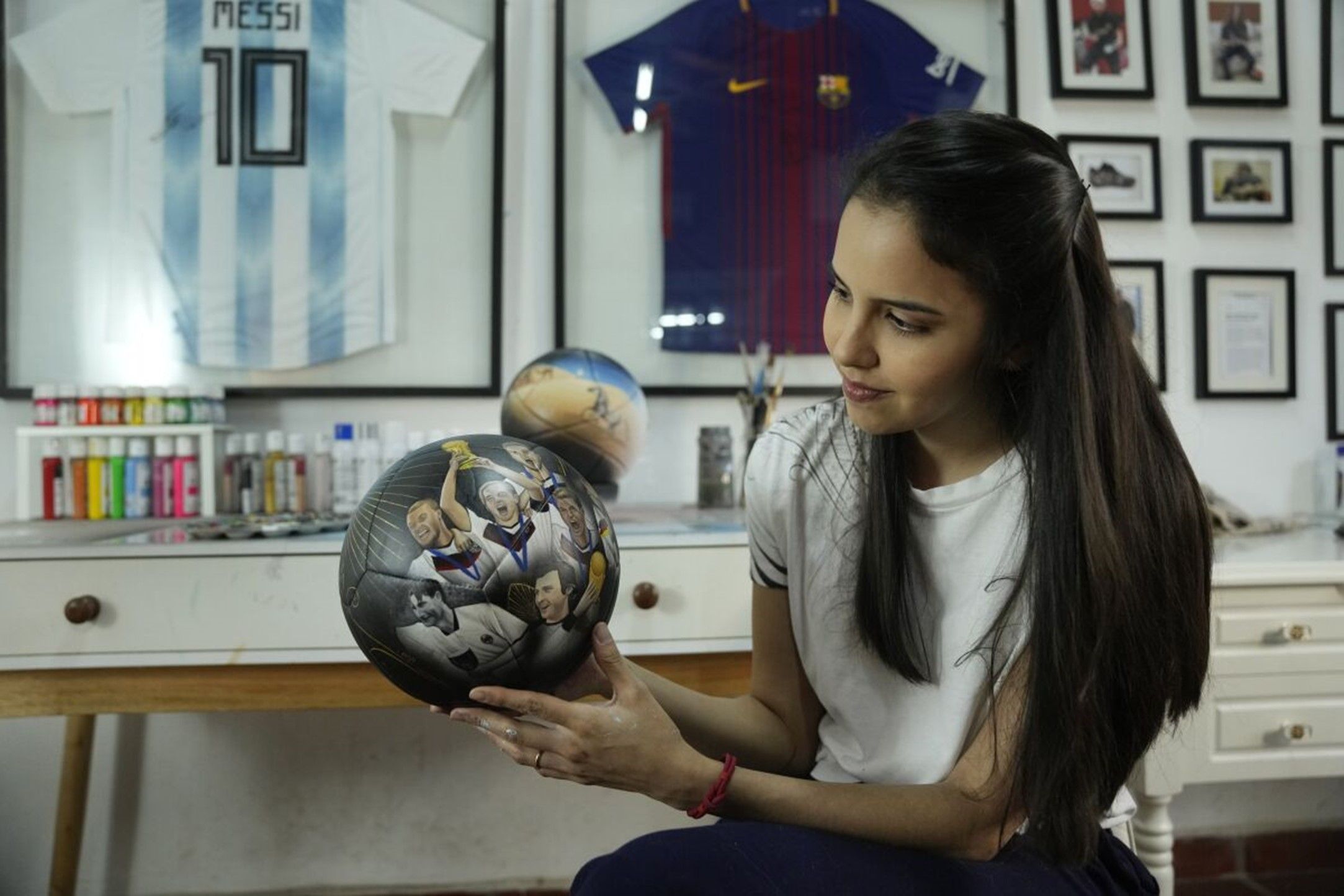 Artista paraguaya despliega su creatividad sobre balones y zapatos de fútbol para Qatar 2022